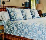 Bed with blue and white patterned bedding and pillows.