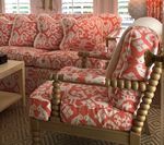 Living room with coral and white patterned sofa and chair, beige rug.