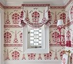 Red and cream patterned wallpaper and window with a draped valance.