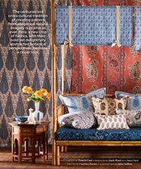 Interior with paisley fabrics, a wood bed, and small table.