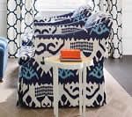 Armchair and side table with patterned fabric, curtains, and orange box.