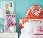 Bed with patterned orange headboard against a teal wall. Nightstand with lamp and Beatles poster.