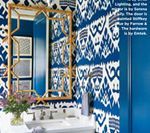 Blue patterned wallpapered powder room with gold mirror and white sink.