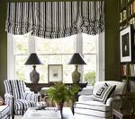 Living room with striped window treatment, chairs, and lamps.