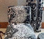 Chair with black and white patterned fabric and matching curtains.