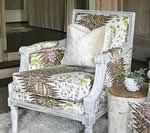Upholstered armchair with floral print fabric and a white pillow; light wood frame.