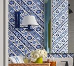 Bathroom with blue patterned wallpaper, a white lamp, and a basket holding items.