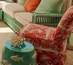 Living room furniture: green sofa, red patterned chair, teal fish-decorated stool.