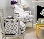 Two light gray armchairs with diamond pattern fabric in a white room.
