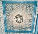 Blue-framed decorative ceiling panel with an intricate latticework pattern and a central floral design.