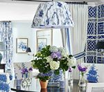 Dining room with blue and white floral patterned decor and large flower arrangement.