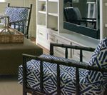 Living room with bamboo furniture, blue and white patterned cushions, and built-in shelving.