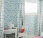 Room interior with blue wave-pattern wallpaper, white curtains, a white table with a mirror, and a chair with a pink heart.