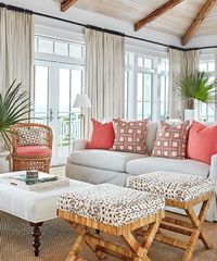 Living room with sofa, leopard print ottomans, and sheer curtains.