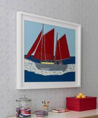 Framed artwork of a red-sailed ship on blue water, against a blue sky.