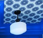 Blue ceiling with patterned wallpaper and white light fixture.