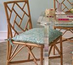 Bamboo chair with patterned cushion.
