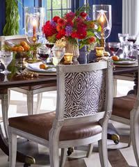 Elegant dining table set with zebra-print chair back, floral centerpiece, and place settings.