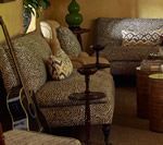 Living room with patterned sofa, guitar, small tables, and decorative items.