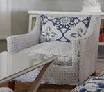 White armchair with blue patterned pillow.