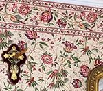 Floral wallpaper with a cross and a framed mirror.