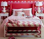 Red bedroom with bed, nightstands, and patterned bench.