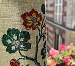 Floral curtain in front of a European building with colorful flowers in a pot.