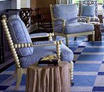 Two blue patterned armchairs in a room with blue and white checkered floors.