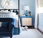 Bedroom with blue walls, a white bed, and a dog.