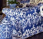 Blue and white patterned sofa and decorative jar; black and white striped floor.