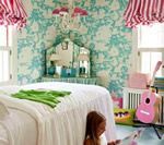 Girl in colorful bedroom with floral wallpaper, pink guitar, and striped window coverings.