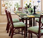 Dining room with glass table, green placemats, burgundy chairs, and floral artwork.
