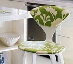 White stool with green floral seat and back in a kitchen setting.
