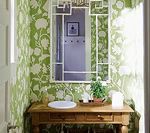 Green floral wallpapered entryway with wooden console table, decorative mirror, and potted plant.
