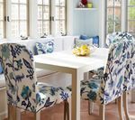 Dining room with white table and chairs with floral patterned upholstery, built-in bench.