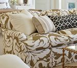 Couch with floral pattern upholstery and decorative pillows in neutral tones.