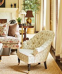 Living room with patterned chair, sofa, and floor rug.