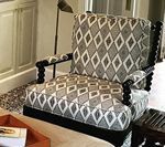 Diamond-patterned upholstered armchair with black trim; indoor setting.