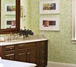 Bathroom with dark wood vanity, light green patterned wallpaper, and framed artwork.