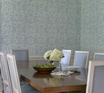 Dining room with wooden table, white chairs, floral centerpiece, and patterned wallpaper.
