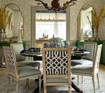Dining room with table, chairs, mirrors, and chandelier.