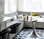 Kitchen nook with patterned upholstery, a chrome tulip table, and geometric tile floor.