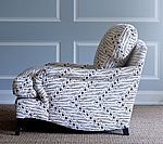 Upholstered armchair with blue and white patterned fabric against a pale blue wall.