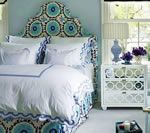 Bedroom with blue and white patterned headboard, bedding, and nightstand.