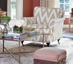 Chevron-patterned armchair with ottoman and coffee table in a living room.