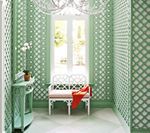 Green trellis-patterned walls in a hallway with white bench, arched doorway, and a matching console table.