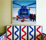 Blue and red helicopter artwork above a crib with red, white, and blue zig-zag pattern.