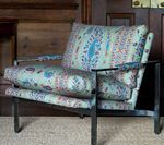 Armchair with patterned upholstery and metal frame.