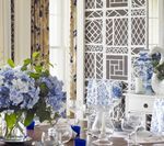 Elegant dining room with blue hydrangeas, blue and white decor, and a decorative screen.
