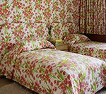 Twin beds with matching floral bedding and curtains.